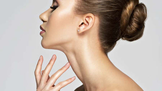 Woman applying skincare products to her neck.