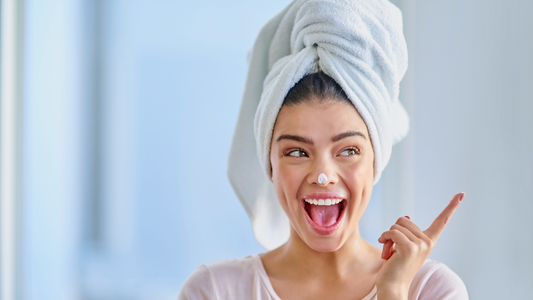 happy woman with her hair in a towel right after her at home facial.