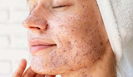 Woman exfoliating her skin on her face during her morning routine.