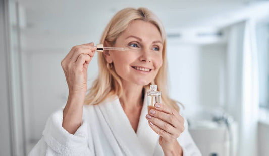 Woman putting skincare serum on her skin in the morning.